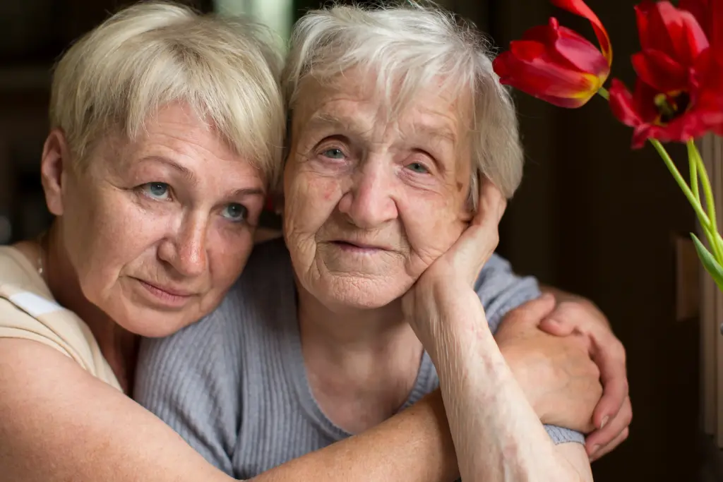 Tochter umarmt ihre ältere Mutter – Symbol für Zuwendung und Unterstützung pflegender Angehöriger