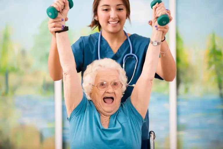 Seniorin hebt mit Unterstützung einer Pflegekraft Hanteln und lacht dabei.